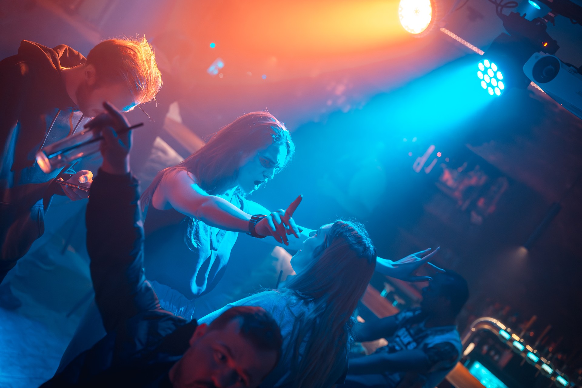 Feestende gasten in blauw en oranje licht tijdens een avond in Bar Lardo